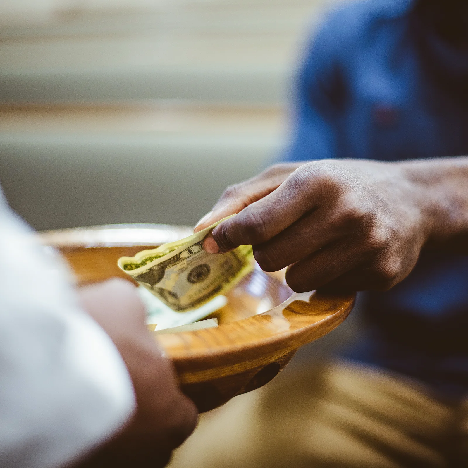 man placing tithe in the offering plate