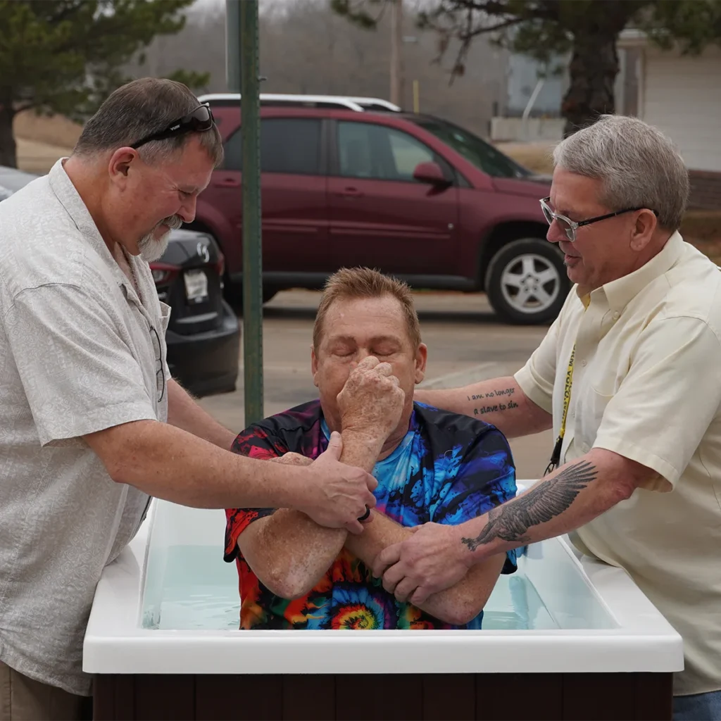 union rescue mission team members baptizing man in tie dye